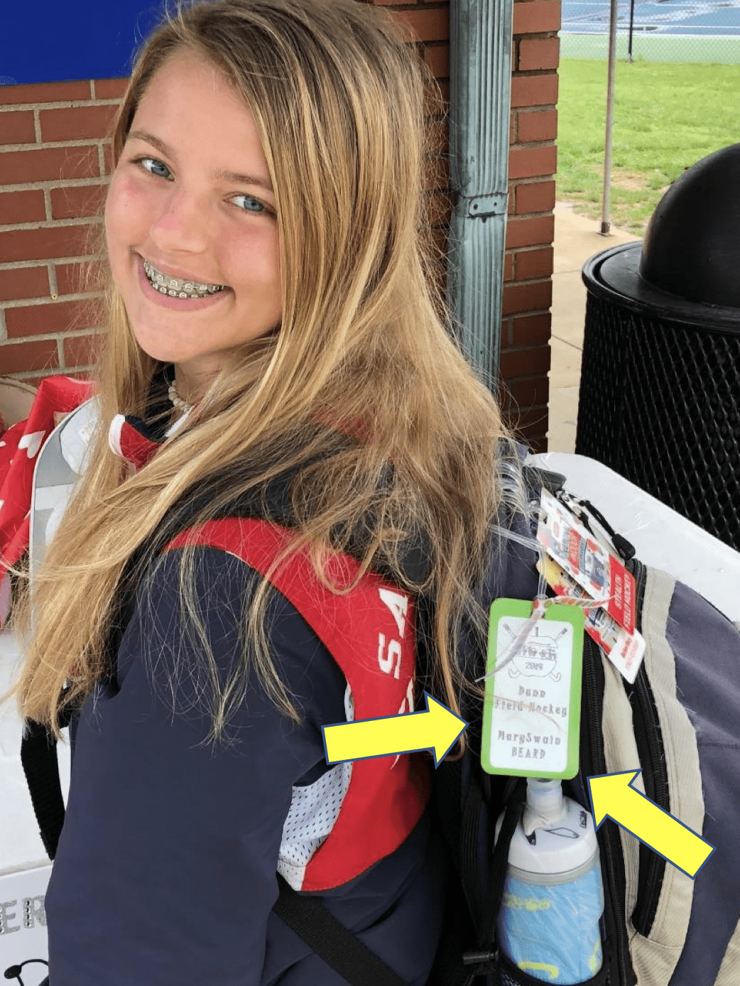 A student proudly showing off Her backpack and tags