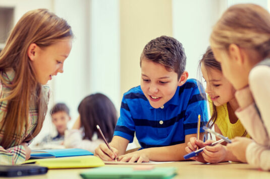 Team of engaged students at a desk with schoolwork